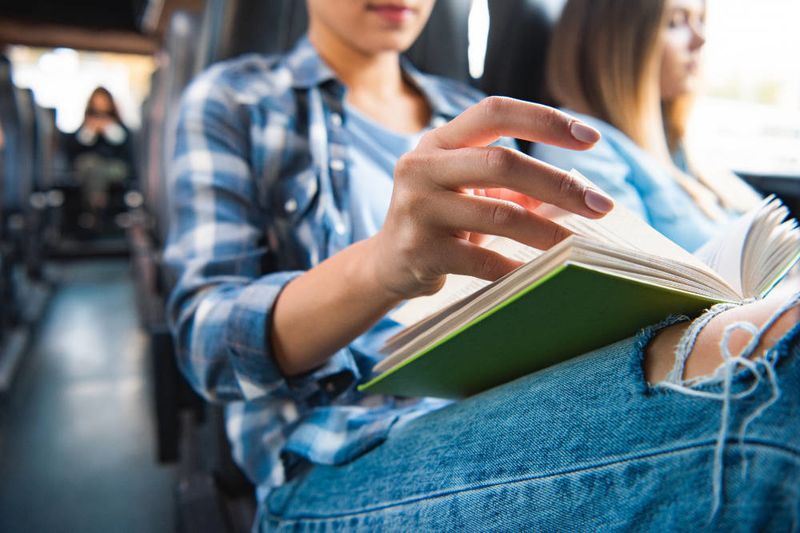 Fahrgast mit Buch in einem Bus